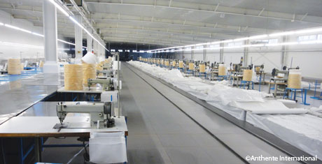 Interior view of the new factory in Shandong, China with a bank of new industrial sewing machines.